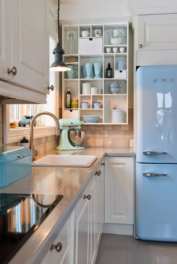 A glossy sky blue fridge and a matching box, a mint mixer and matching mugs.