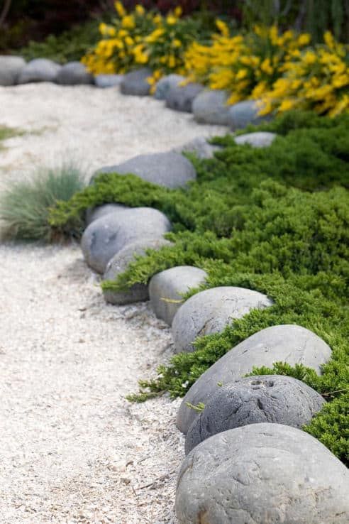 Oversized rocks and white garden pathways create an Asian feeling in the garden makign it all-natural yet manicured.