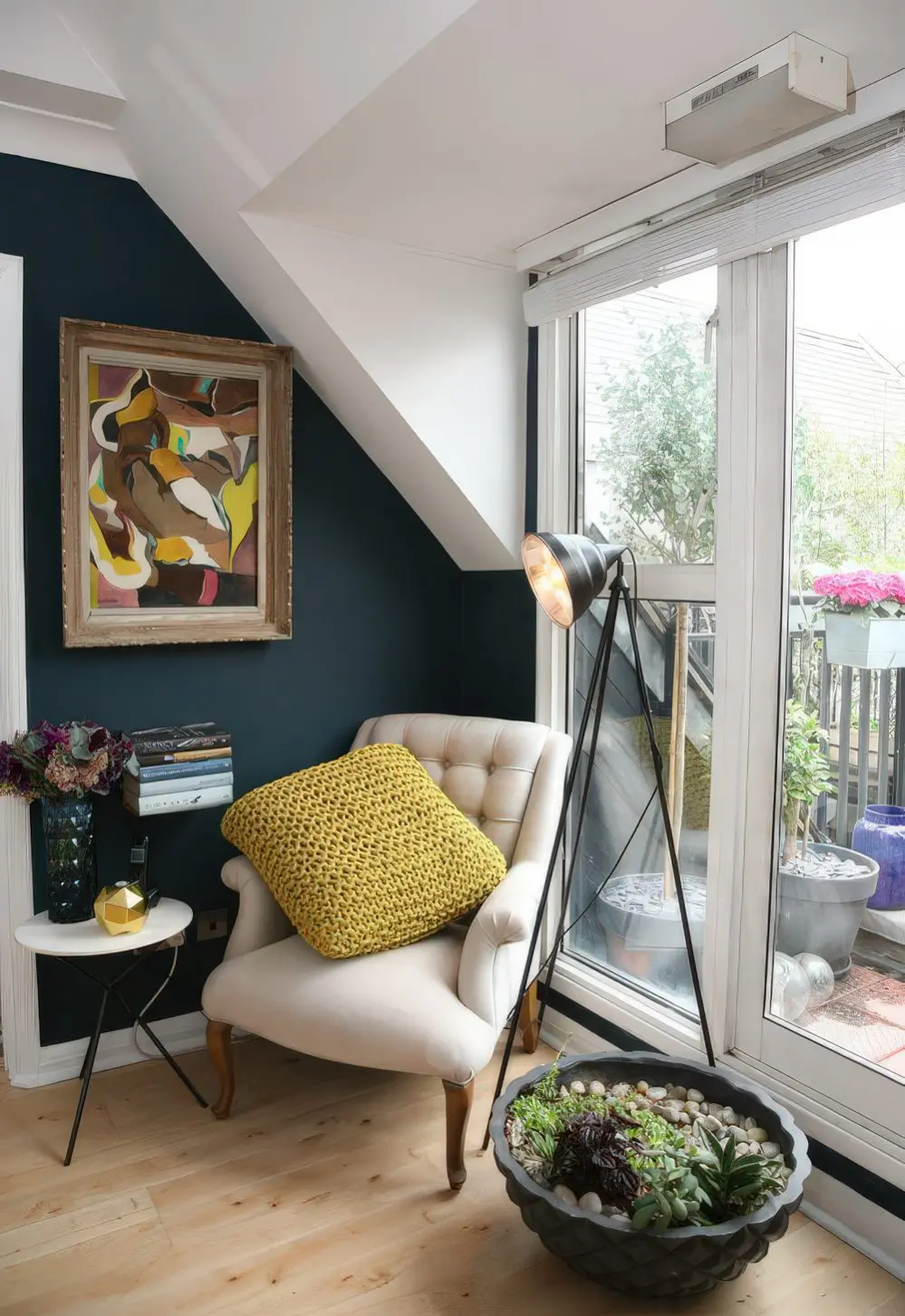 A cozy reading nook by the window, with an artwork, succulents and a small side table.