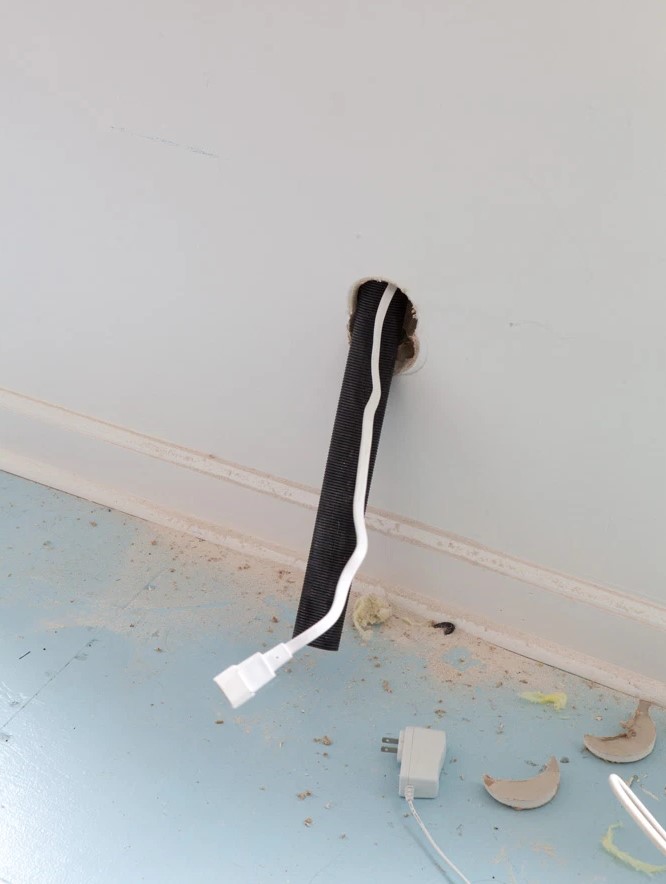 Use a tube that goes inside the wall to make the look uncluttered and accurate, and make an outlet behind the TV to minimize the look.