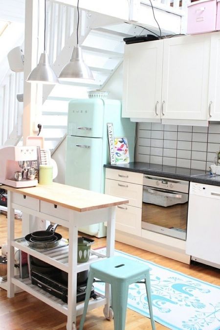 A mint Smeg fridge and a matching stool for a small and cozy neutral kitchen.