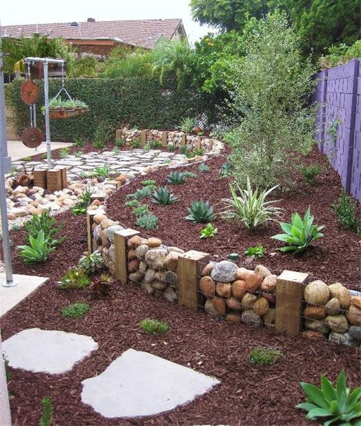 A gabion wall used as garden edging blends with the natural environment making it fresh and cool.