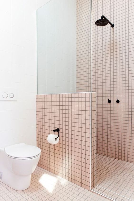 Light pink tiles are highlighted with black grout and contrasting white touches.