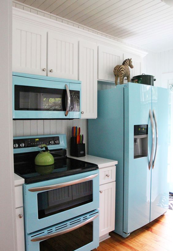 A blue fridge, microwave and cooker spruce up the traditional white kitchen.