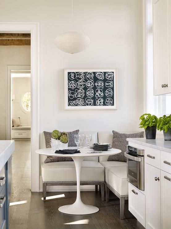 A cozy eat-in kitchen nook with an L-shaped bench and a round small table is what you need for breakfasts.
