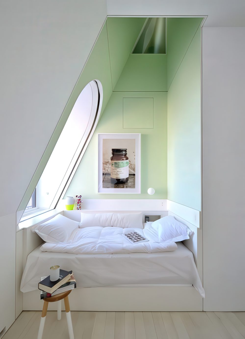 An awkward attic corner is taken by a whole comfy bed where you can have a daytime nap or jsut read.
