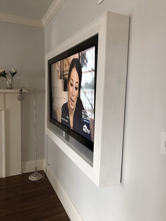 Such a white frame around the TV will hide all the wires away and will keep your wall-mounted TV look elegant and very sleek.
