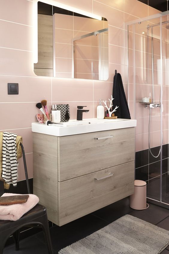 Large scale pink tiles and black ones on the floor for a catchy look and light-colored wood for warmth.