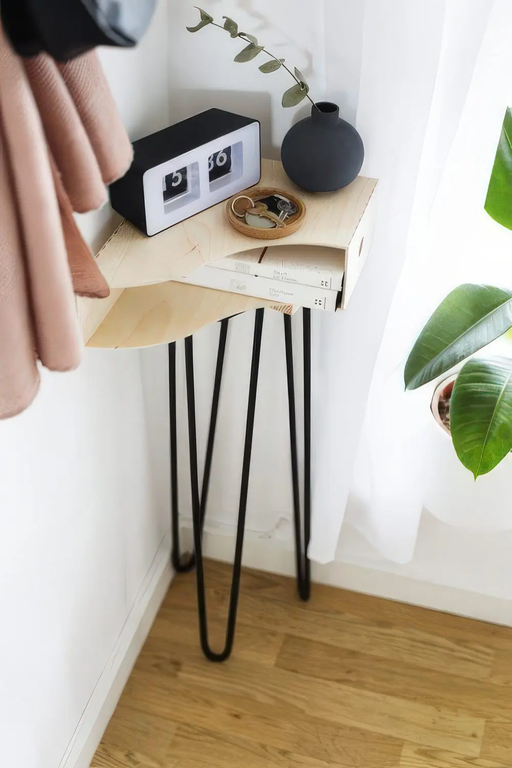 A small side table on hairpin legs used in a small corner to make the use of it.