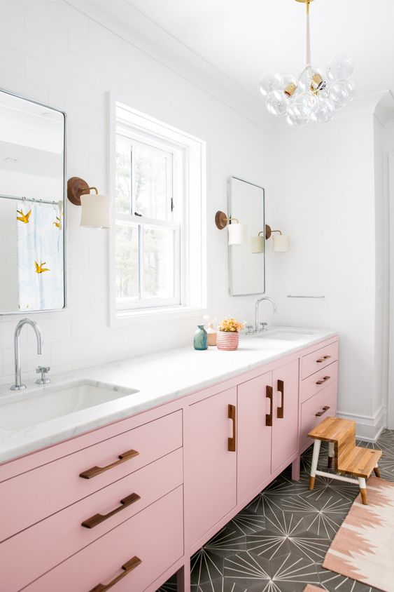 A long and large light pink console with wooden handles and a marble top for a chic glam look.