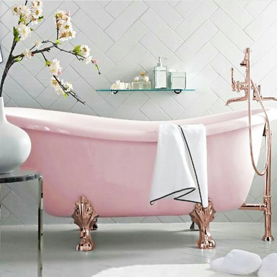 A refined pink bathtub with copper clawfoot legs for a gorgeous and sophisticated space.