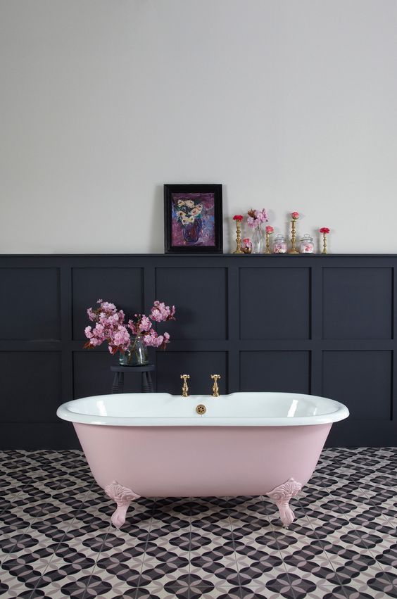 A vintage girlish bathroom with a pink clawfoot bathtub for a chic look.