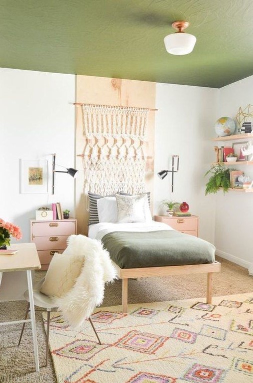 A teen room featuring a vibrant green ceiling, enhanced by a macrame hanging for a touch of boho charm. Floating shelves provide practical storage, while pink nightstands add a pop of color. The small desk and chair offer a cozy study area, perfect for homework.