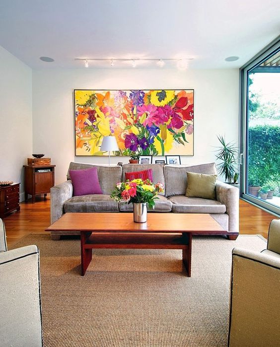 A bold floral artwork, bold blooms in a vase and colorful pillows to make your living room extra bold.