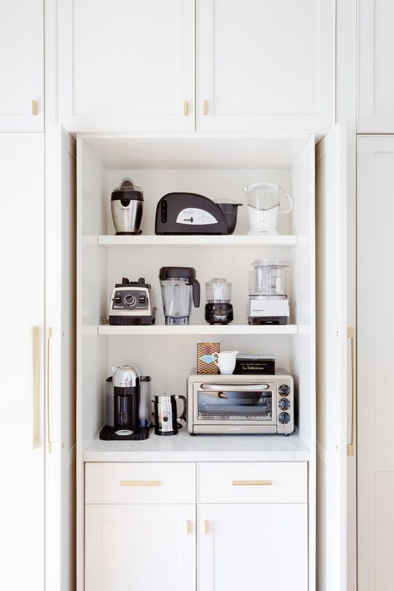 A cabinet with shelves holding various appliances is a cool and stylish idea to store them without cluttering the space.