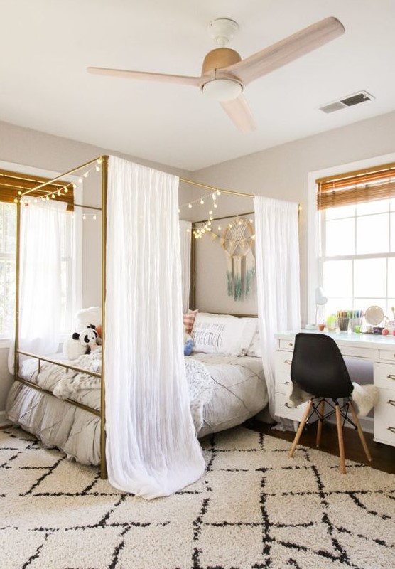 Step into a cool teen room with a large canopy bed adorned with lights and a white desk. The black chair and shades add contrast, making it a pretty space. This room design combines elegance with practical features.