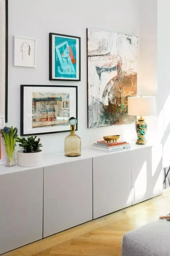 A dove grey IKEA Metod credenza with decor, potted plants, lamps and a bold gallery wall.