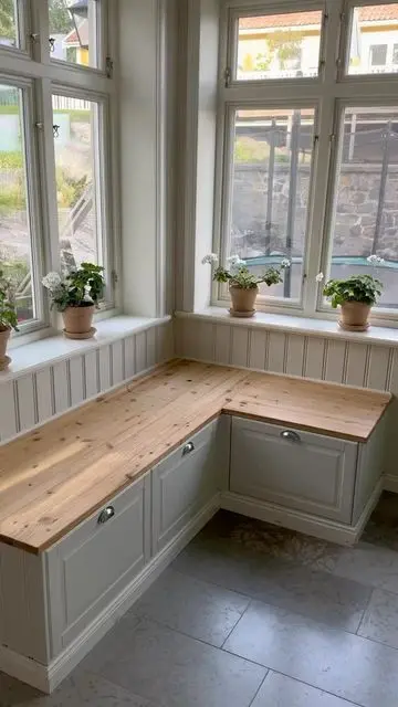 A farmhouse corner storage bench of IKEA Metod units, with shaker drawers and a butcherblock countertop.