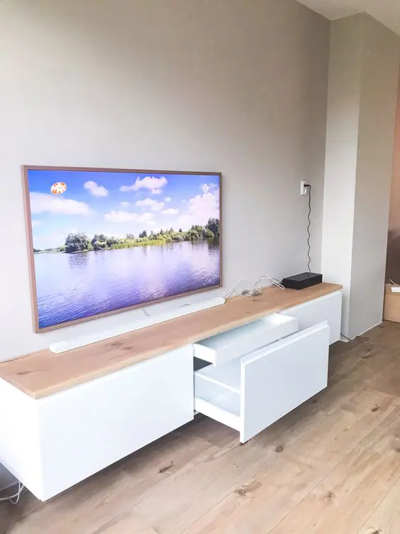 A floating white TV unit of IKEA Metod, with a butcherblock countertop for a Scandinavian space.