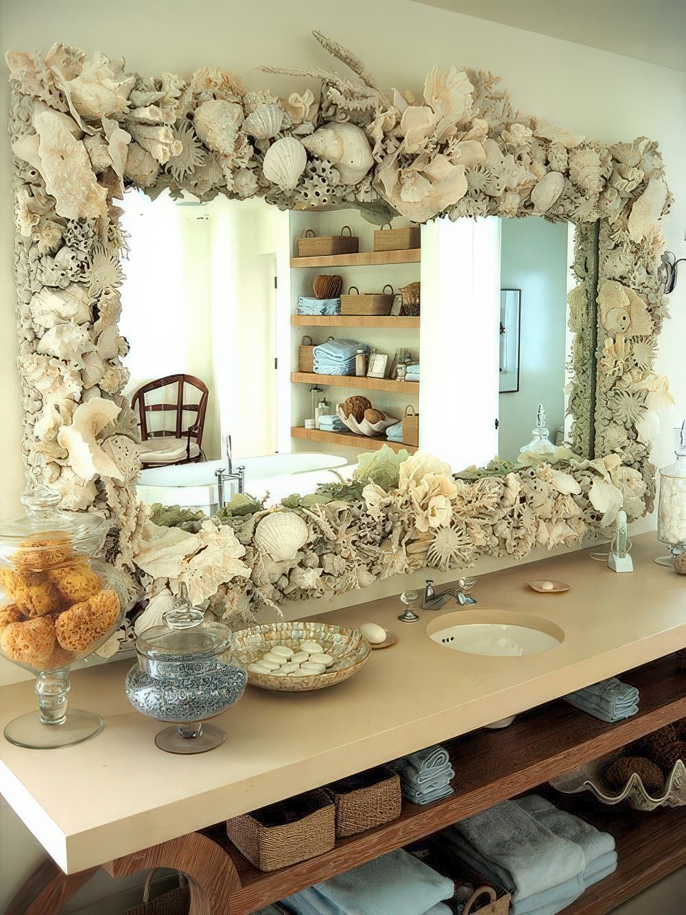 A large mirror fully clad with seashells, corals and sea urchins is a cool idea for a coastal or beach bathroom.