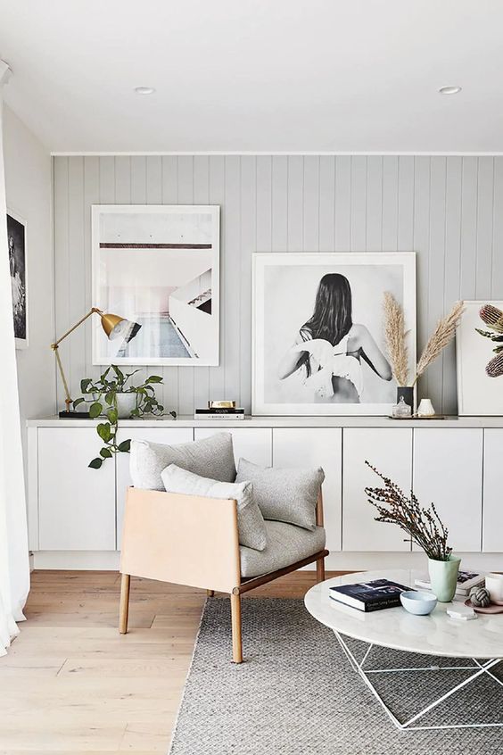 A large white sideboard composed of IKEA Metod cabinets, with large artwork, greenery, pampas grass and a gold table lamp.