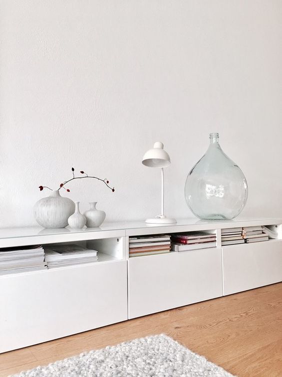 A long white sideboard of IKEA Metod units, with books, lamps and vases is ideal for a Scandinavian space.