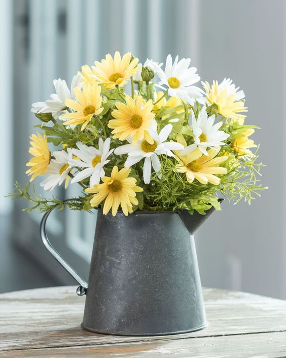 A metal teapot with bright summer blooms for a rustic summer feel in your space.