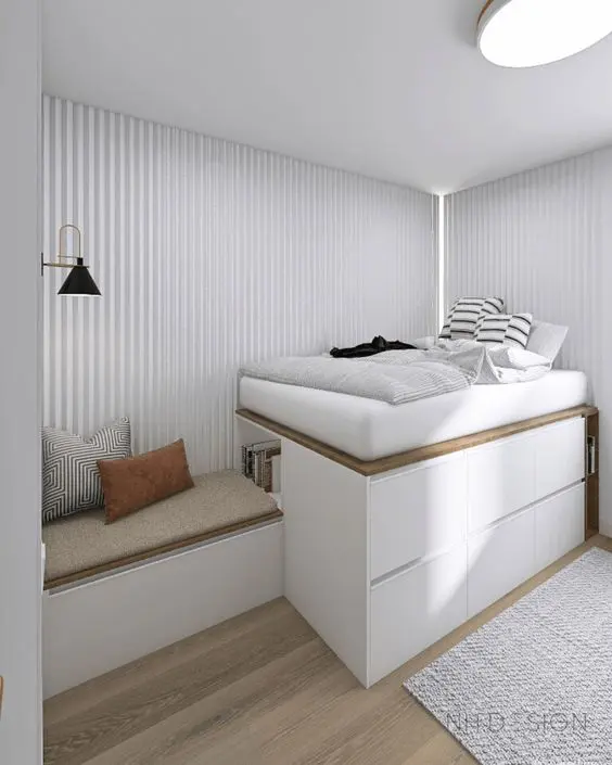 A minimalist sleeping space with a storage bed built of IKEA Metod units, a bed and a bench with pillows.