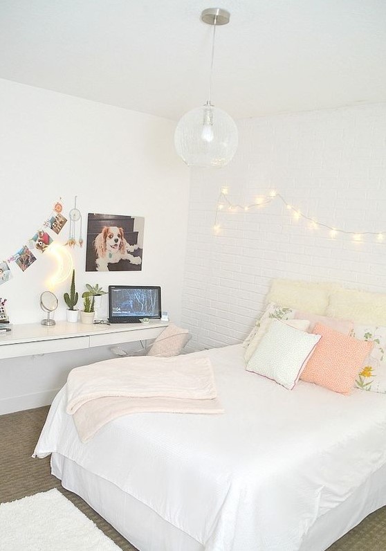 Create a neutral teen bedroom with a floating desk and vanity, paired with a bed featuring pastel pillows. Wall lights enhance the ambiance, making it a cozy space. This design offers a practical and soothing environment.