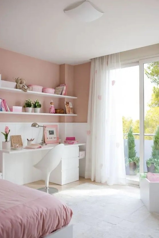A romantic dusty, blush pink and white bedroom with pink bedding, heart printed curtains and simple white furniture.