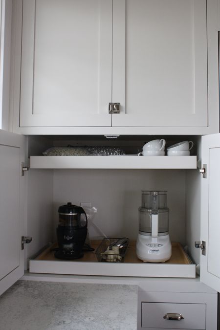 A small cabinet with retractable shelves that hold appliances and mugs is a cool idea to make your own tea and coffee station hidden.