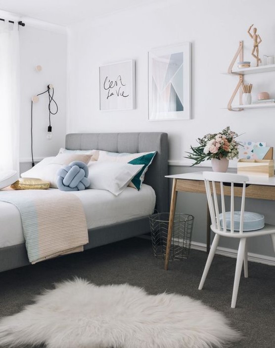 Create a stylish modern teen girl bedroom featuring a gallery wall and a grey upholstered bed. A small desk and touches of powder blue, blush, and gold complete the look. This design combines modern style with a personal touch.