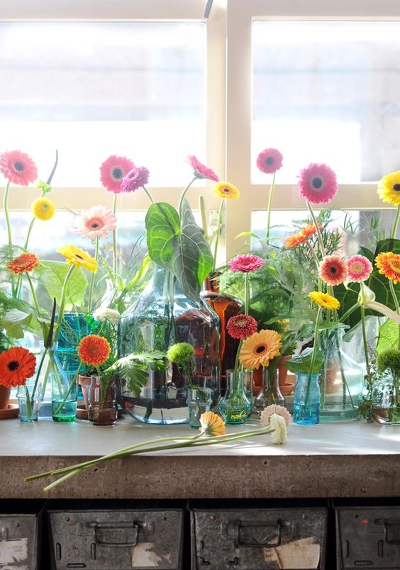 A whole arrangement of colorful bottles, jars and vases with lots of bright gerberas is a lovely summer idea.