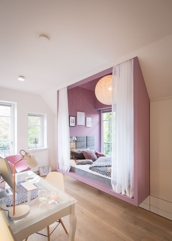 Create an ultra-modern teen girl bedroom with a bold purple alcove sleeping space near the window. A white studying zone enhances the room's functionality. This design offers a vibrant and contemporary space.