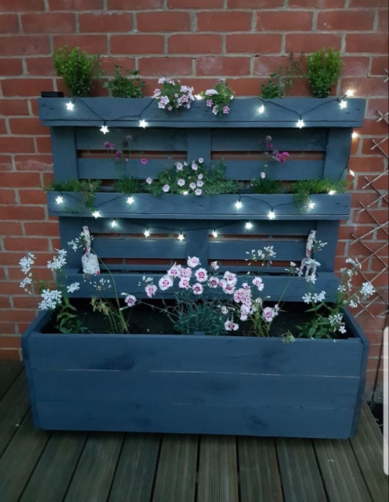 This black planter with an additional vertical part is a lovely planter and plant stand at the same time.
