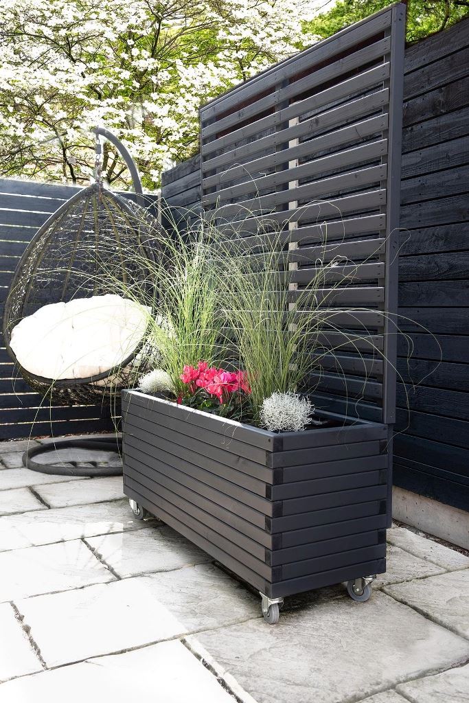 This black slat planter includes a trellis and casters to move it where you need. Such a piece will easily become a perfect space divider.