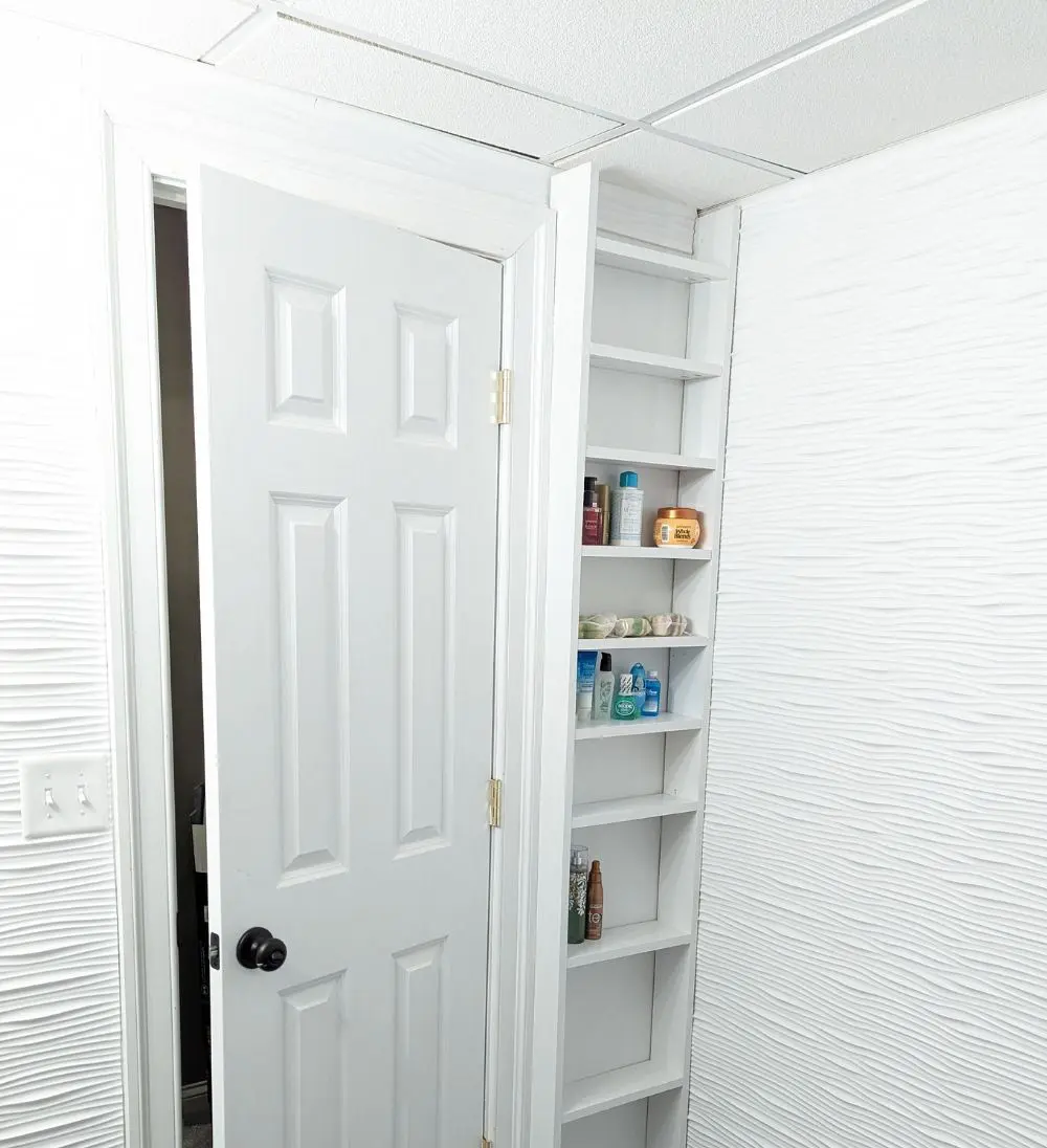 Place built-in shelves on the same wall as the door, so this shelf won't prevent it from opening.