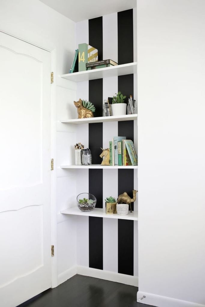 This is my favorite idea for the behind the door space: built-in shelves are used to display various objects and striped wallpaper accents the nook.

(via apartmenttherapy).