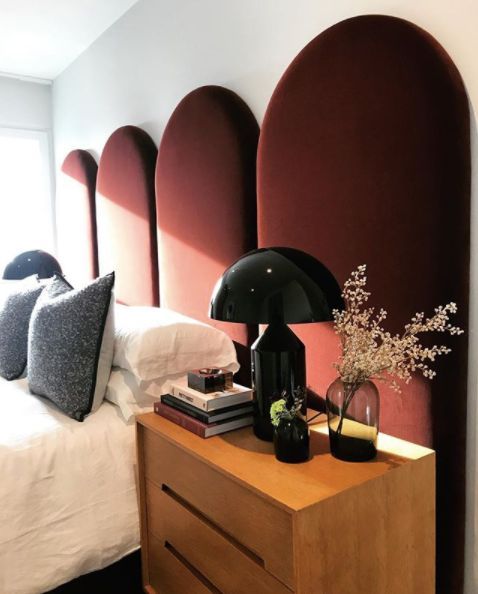 This burgundy scallop headboard is a statement feature in the space that adds color, shape and interest to the room.