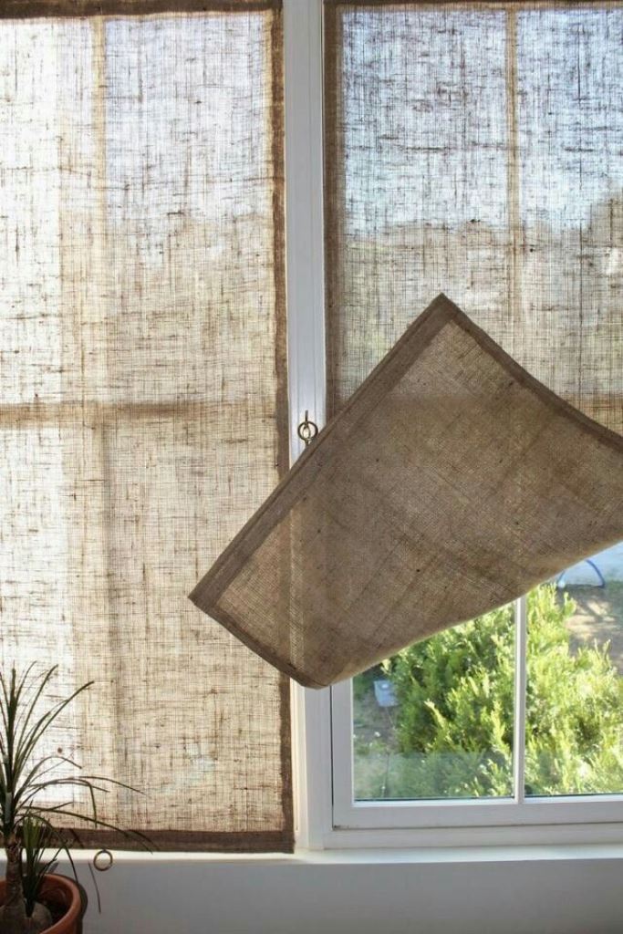 Semi-sheer burlap Roman shades are great to block the view without blocking the light and to add a rustic touch to the space.