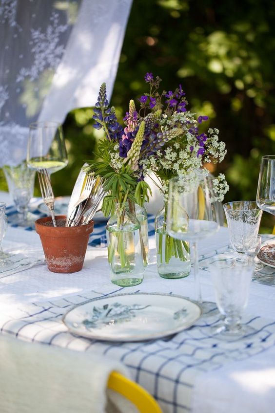 Clear bottles with purple and white blooms are a cool summer centerpiece or decoration.