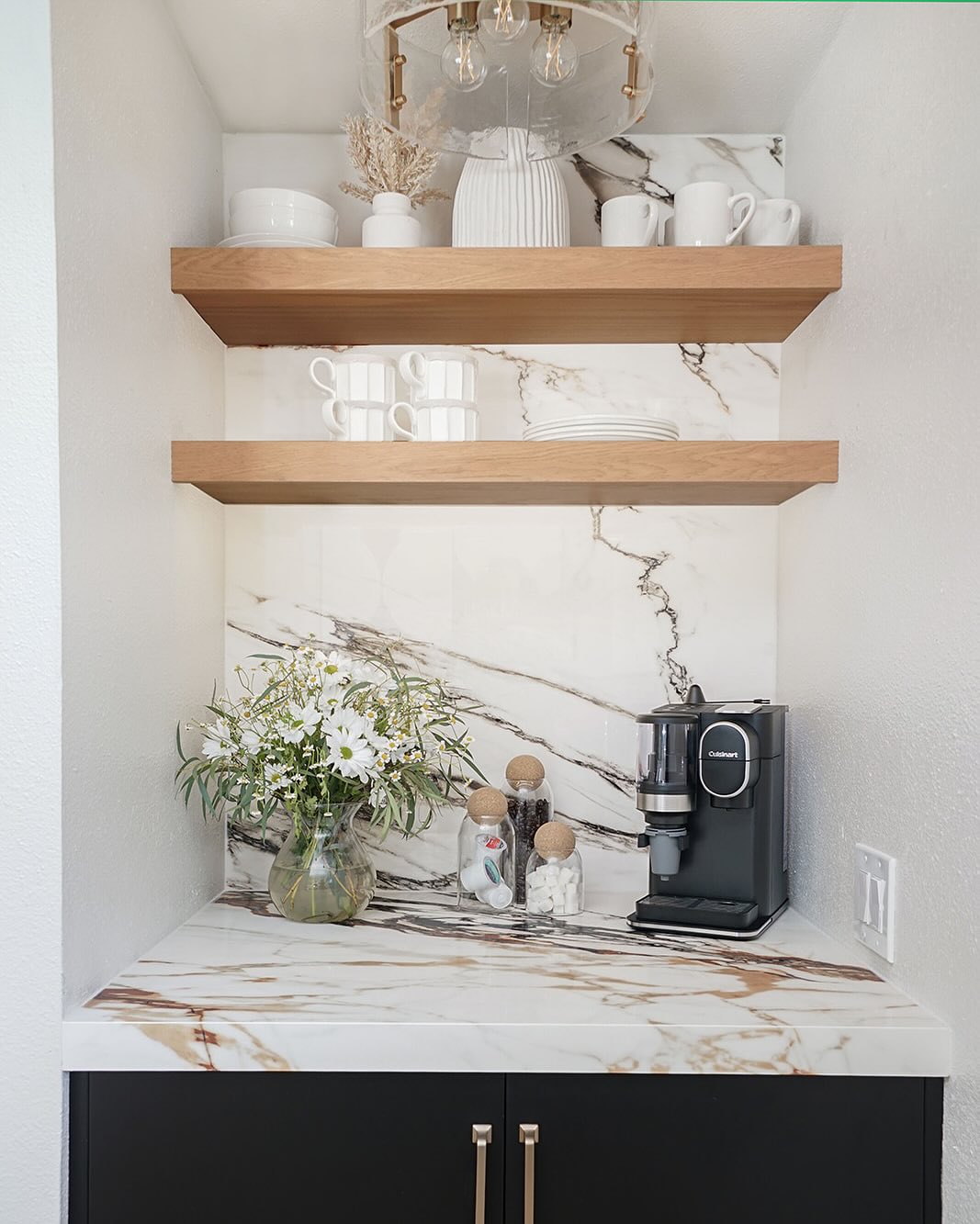 A marble backdrop and floating wood shelves turn this narrow niche into a luxe coffee nook—tiny, but it feels straight out of a boutique hotel.

(@shadesofgrayinteriors).