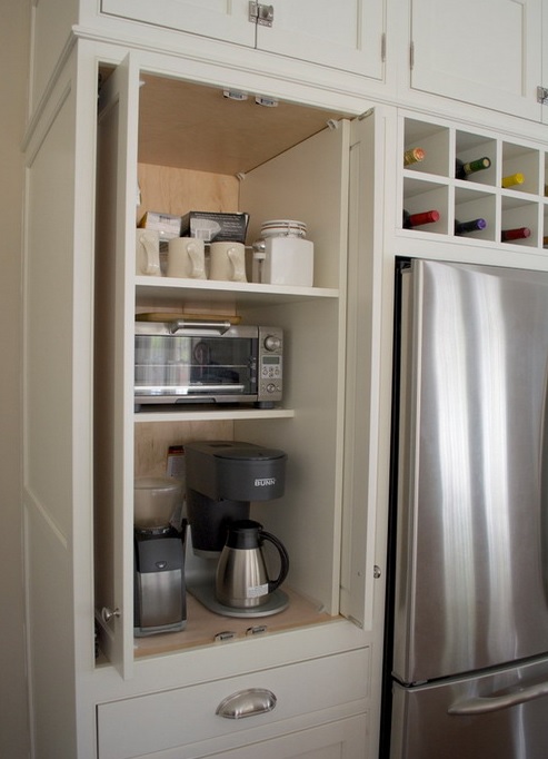 A neutral cabinet hides several appliances, sugar, tea and mugs is a lovely coffee or breakfast station.