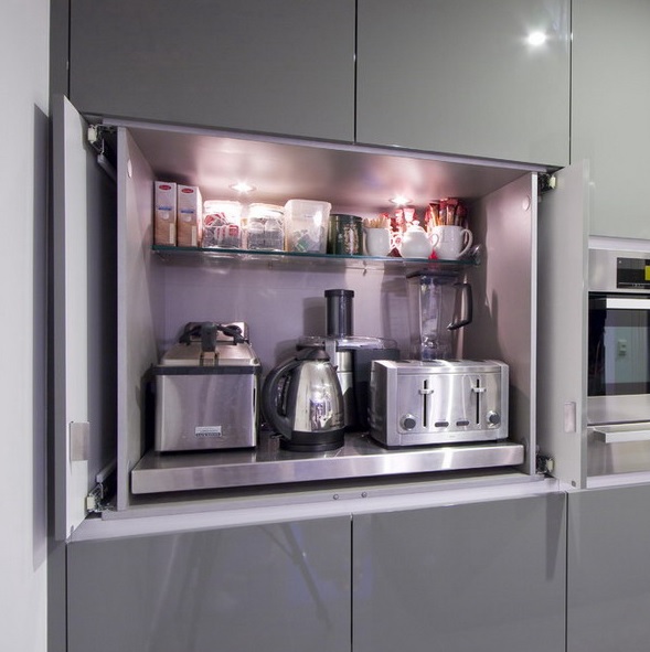 A sleek cabinet with glass and metal shelves inside, with appliances and some mugs and food inside will keep any space decluttered.