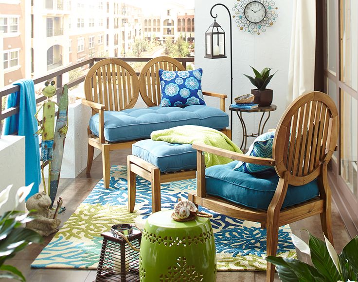A bright and cheerful summer balcony done in blue and green, with chic vintage-inspired furniture and bright textiles.