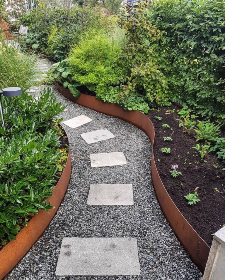 The modern garden is done with curved garden beds and corten steel edges. The path of pavements is also curved.