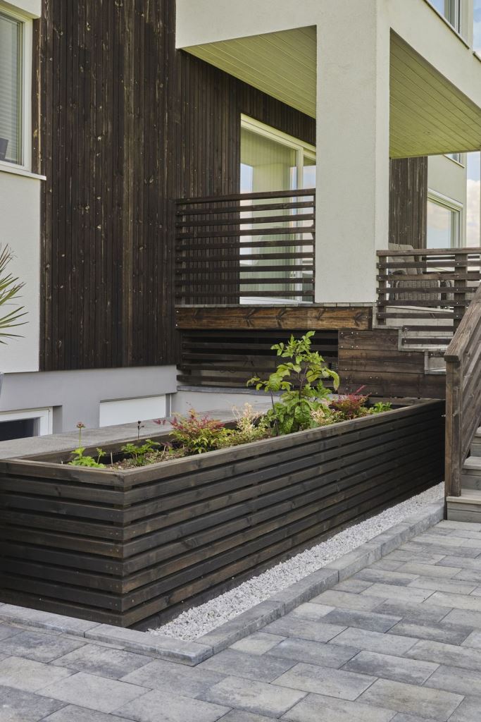 The contemporary front yard features a dark-stained facade, staircase and even garden bed, all matching for a sleek and modern feel. 


(via talgo).