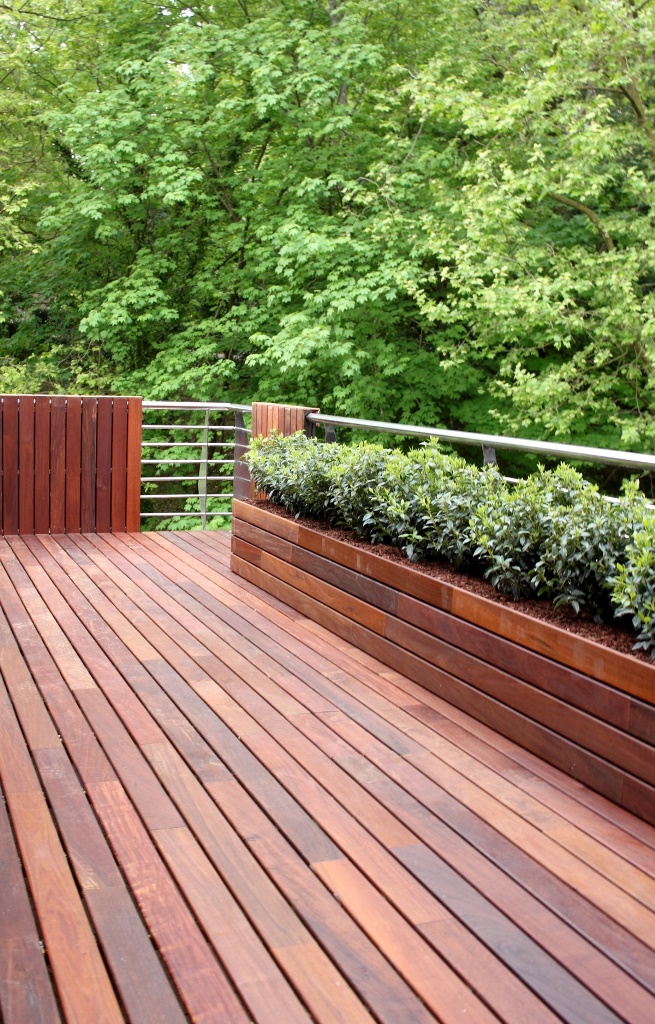 This rich-stained deck includes a built-in planter or garden bed and the combo is stylish.