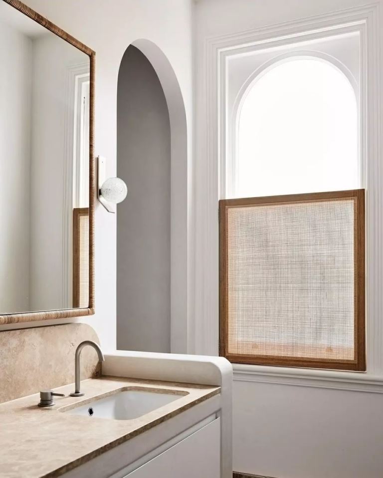 The arched window is treated with a framed burlap piece, which is enough to keep privacy and add interest to the space.