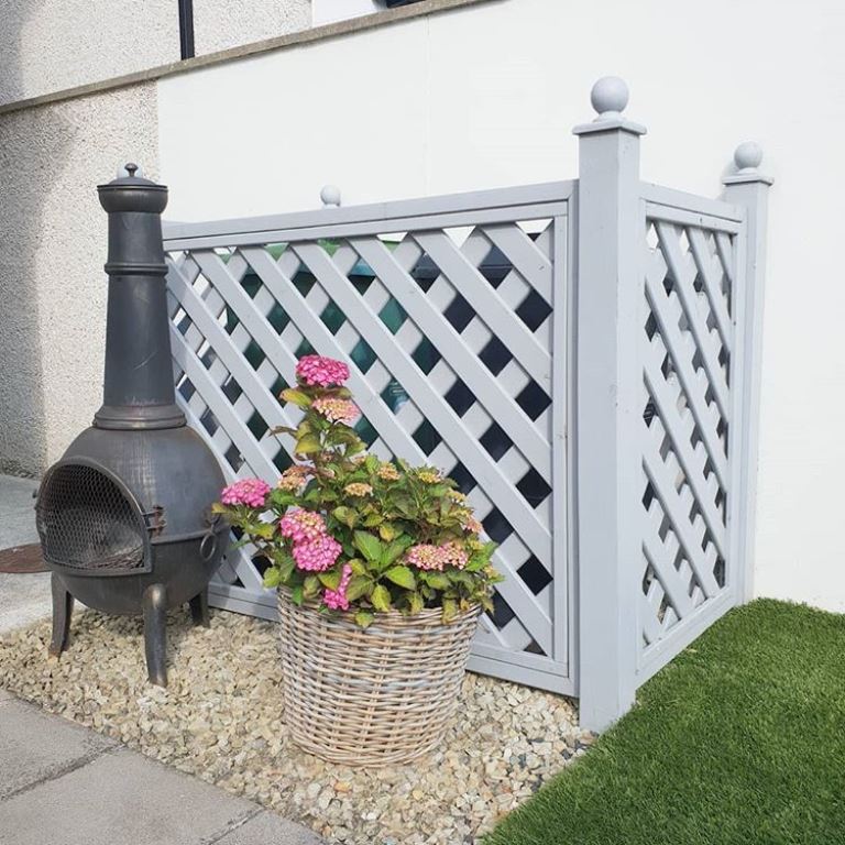 Composing an AC cover of lattice screens is an easy classic solution you can DIY, and they match rustic and farmhouse spaces.